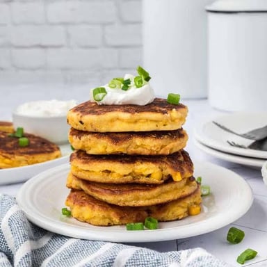 Golden fried cornmeal fritters served on a plate.