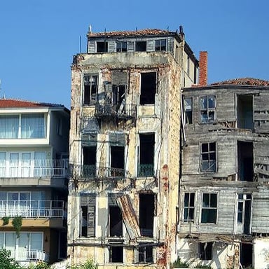 A neglected building standing among homes in a neighborhood.