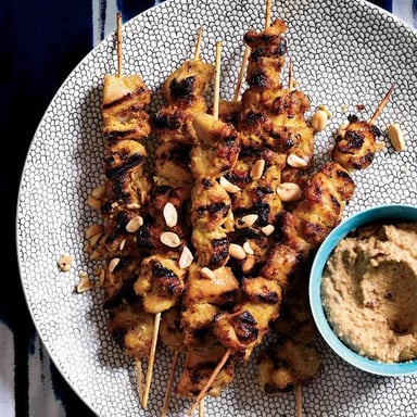 Grilled chicken pieces on skewers served with peanut sauce.