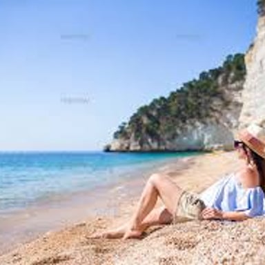 A person lying in direct sunlight on a beach.