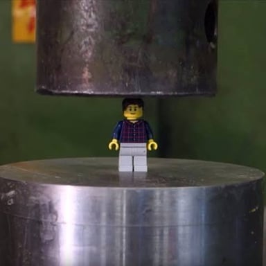 A hydraulic press squeezing an object.