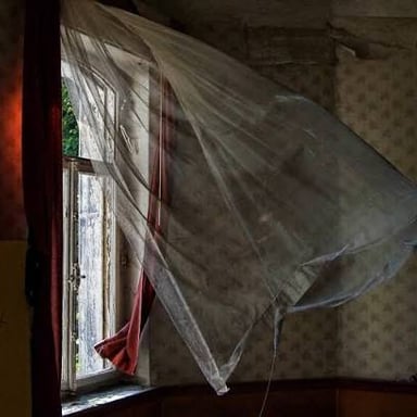 A curtain puffed outward by a strong breeze.