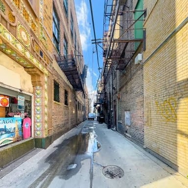 A narrow passage runs between urban buildings.