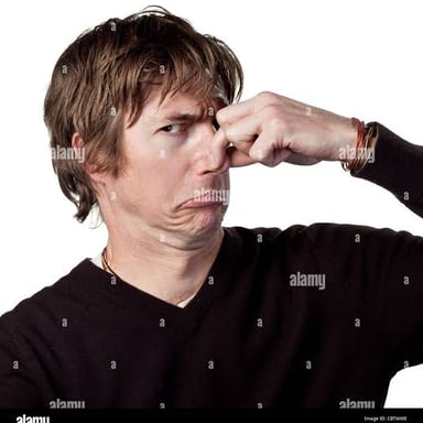 A person pinching their nose in response to an unpleasant odor