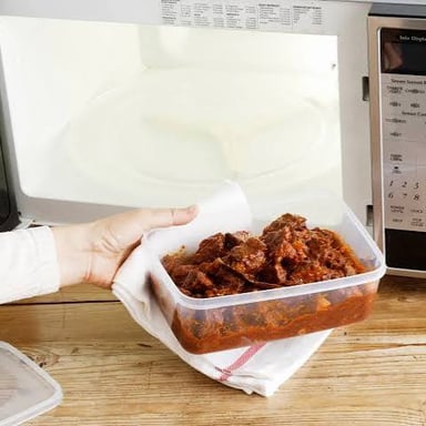A dish of leftovers being reheated in a microwave.