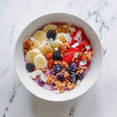 A cereal bowl beside a bowl filled with an acai smoothie mixture and toppings.