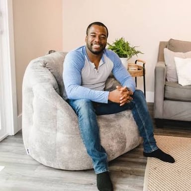 A person seated comfortably on a beanbag chair.