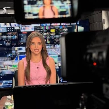 A television presenter speaks to a camera during a live broadcast