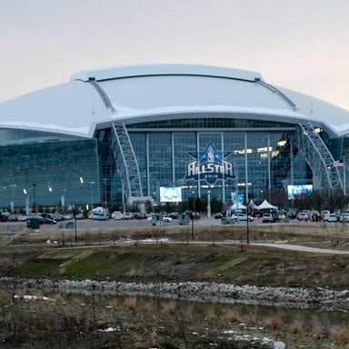 A large stadium with tiered seating surrounding a playing field.