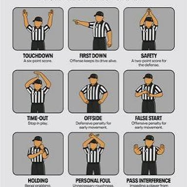 A football official raising both arms to signal a touchdown.