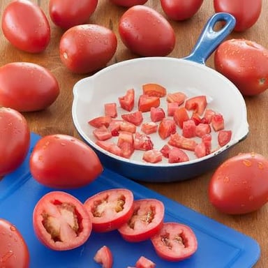 Whole and sliced Roma tomatoes showing their firm, dense flesh.