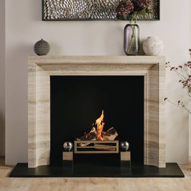 A fireplace hearth has a dusty layer of ash left from a fire.