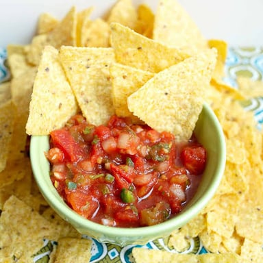 A bowl of salsa served with tortilla chips.