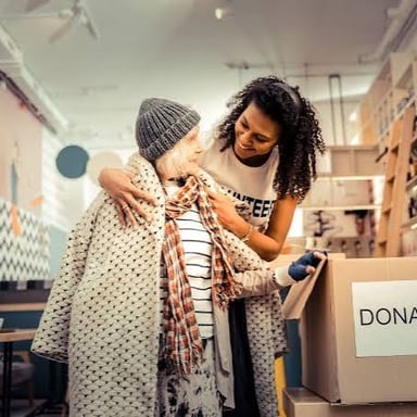 A person handing goods to a charity, illustrating a kind of giving.