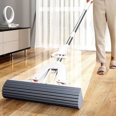 A floor mop with an absorbent head on a hard floor.