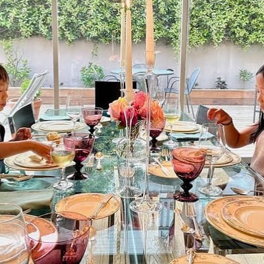 Children demonstrating polite behavior at a dinner table