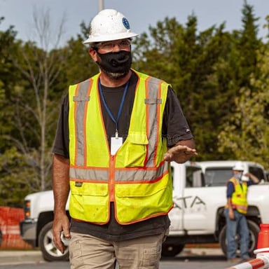 A road worker wearing a high-visibility reflective vest.