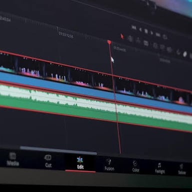 An audio waveform aligned with video clips on an editing timeline.
