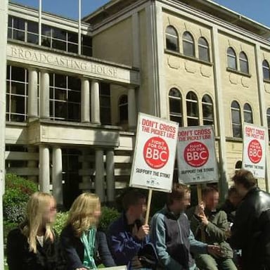 People crossing a picket line during a labor strike.