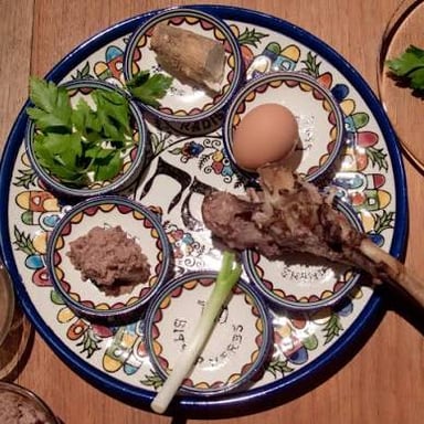 A Passover seder table set with a Haggadah, matzah, and symbolic foods.