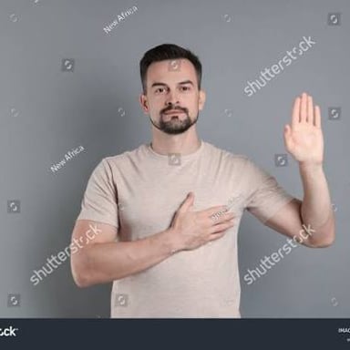 A person raises a hand while making a serious promise.