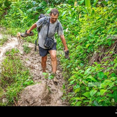 A person trudges slowly along a muddy path.