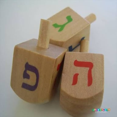 A four-sided dreidel marked with Hebrew letters.