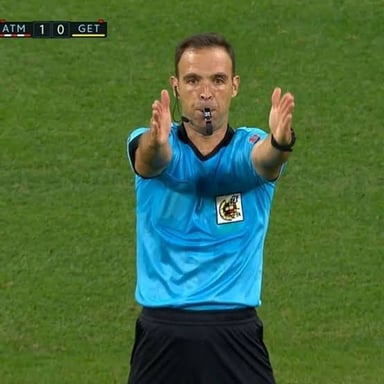 A referee blows a whistle to signal that a game has ended.