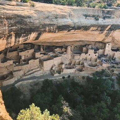 Ancestral Puebloan stone dwellings built into a cliff alcove at Mesa Verde National Park.