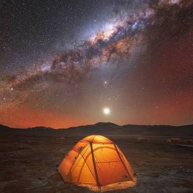 A tent at a campsite beneath a starry sky