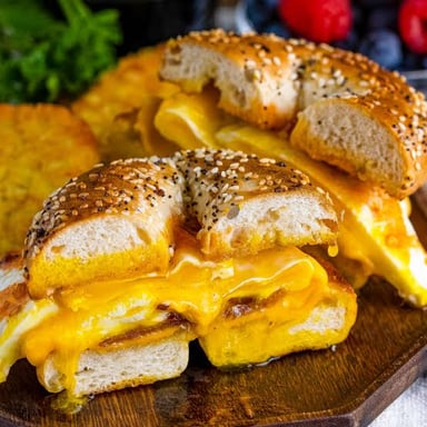 A bagel split and filled with bacon, egg, and cheese.