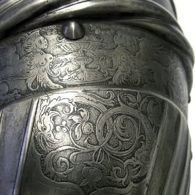 An artist etching a design into a metal plate
