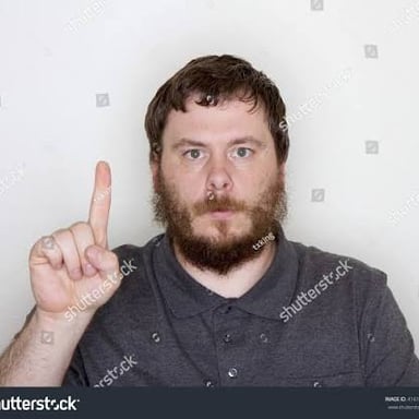 A person holding up one finger to ask someone to wait.