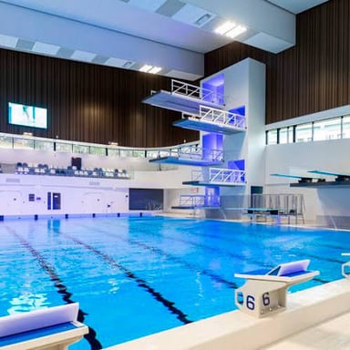 A diving board extending over the water of a swimming pool.