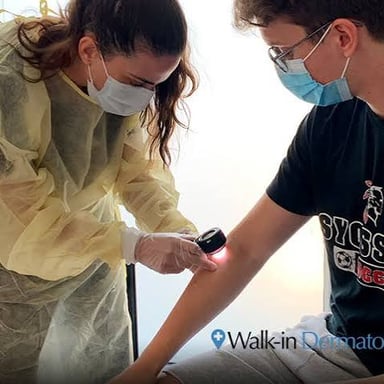 A dermatologist examining a patient's skin during a medical appointment.
