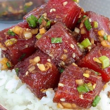 A bowl of ahi tuna poke, with cubed tuna seasoned in a soy-based shoyu sauce.