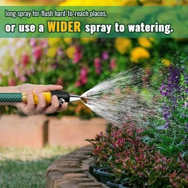 A garden hose spraying water across a paved sidewalk.