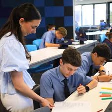 A teaching assistant works with students in a classroom.
