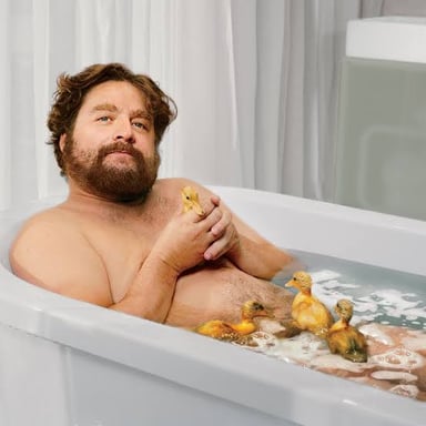 A person bathing in a bathtub.