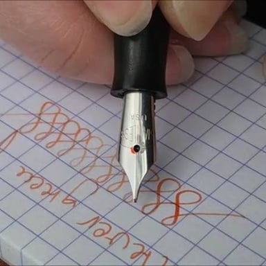 A fountain pen lays a line of ink on paper.