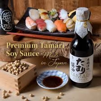 A bottle of tamari, a Japanese fermented soy seasoning, beside a dipping dish.