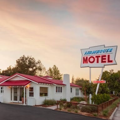 A roadside motel with exterior room doors and a parking area