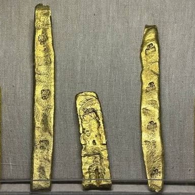 Gold jewelry and a gold bar, representing gold.