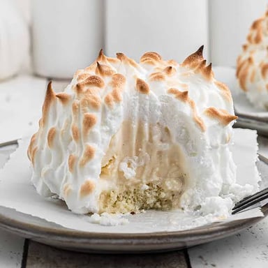 A Baked Alaska dessert with browned meringue covering an ice-cream-and-cake center.