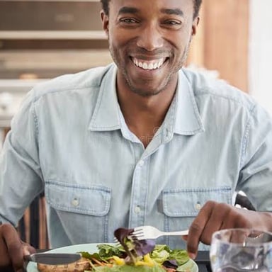 A person eats a midday meal at a table.