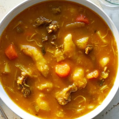 A map locates Haiti in the Caribbean beside a bowl of soup joumou.