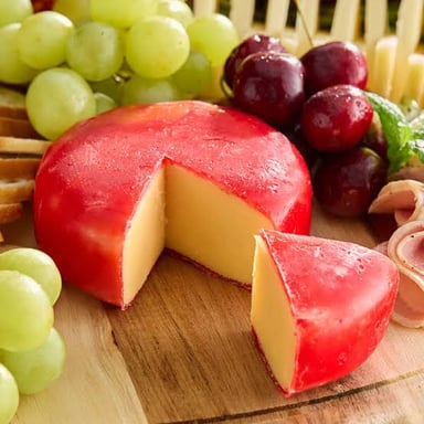 Round Edam cheese wheels, including the familiar red-wax-coated style.