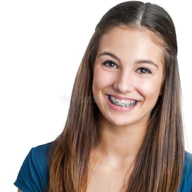 A teenager smiling with braces on their teeth.