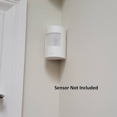 A motion detector mounted on an interior wall.