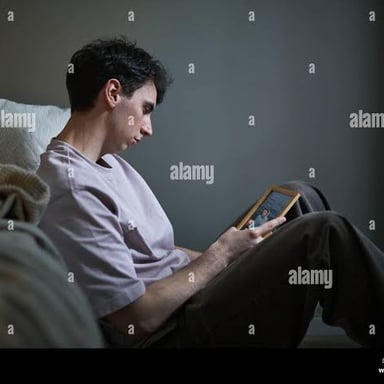A person gazing at a photograph while thinking of someone or somewhere they miss.